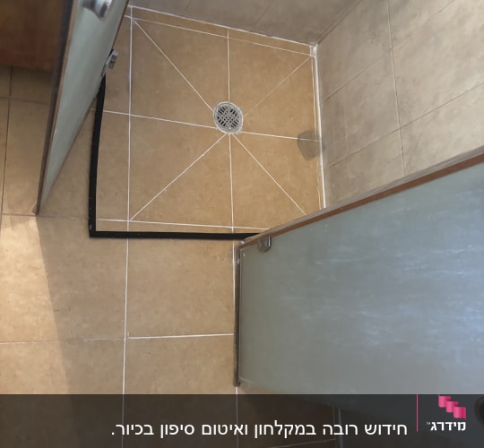 מקלחת עם דלת זכוכית ורצפת אריחים